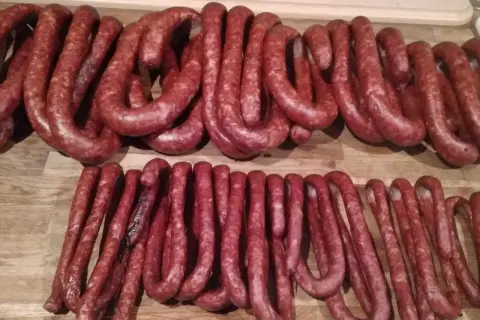 Dwie linie swojskich kiełbas, wędzonych i gotowych do spożycia. Zastanawiasz się, ile wody do kiełbasy swojskiej?