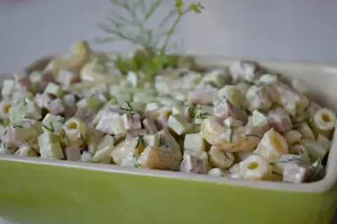 Pyszna sałatka z makaronem, szynką, ogórkiem i koperkiem, polana kremowym sosem. Idealna na każdą okazję!