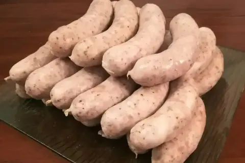 Stos białej kiełbasy, gotowej do przygotowania według przepisu na 5 kg. Idealna na wielkanocny stół.