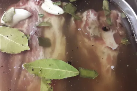 Mięso do pieczenia w zalewie z liśćmi laurowymi i czosnkiem. Peklowanie mięsa do pieczenia to klucz do soczystości.
