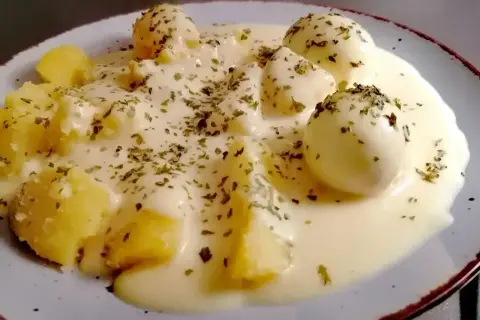 Jajka w sosie musztardowym z ziemniakami, posypane ziołami. Pyszne danie, które zachwyci każdego smakosza.