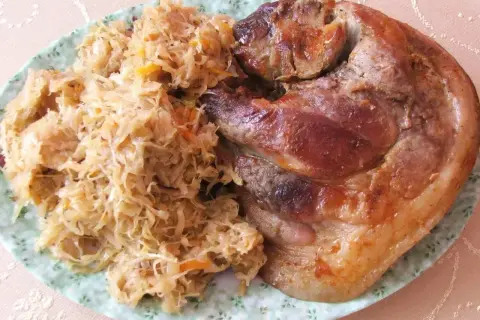 Pyszna golonka w kapuście kiszonej, pieczona do perfekcji, z chrupiącą skórką i soczystym mięsem. Idealny polski obiad.