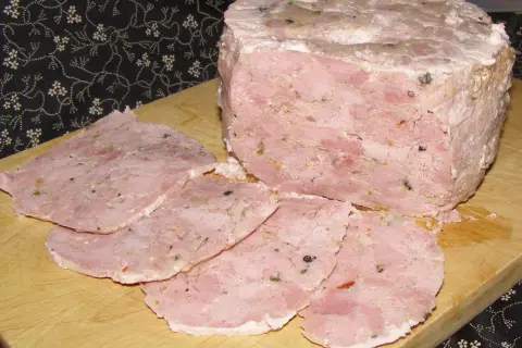 Schab z szynkowara bez peklowania, pokrojony w plastry, z widocznymi kawałkami mięsa i przypraw.