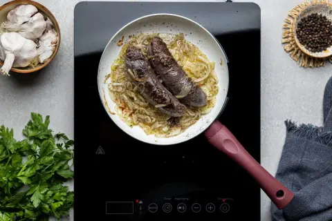 Kaszanka smaży się na patelni z cebulą. Dowiedz się, jak długo parzyć kaszankę, by była idealna.