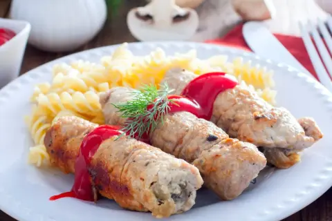 Roladki schabowe z pieczarkami, polane sosem, podane z makaronem fusilli i koperkiem.