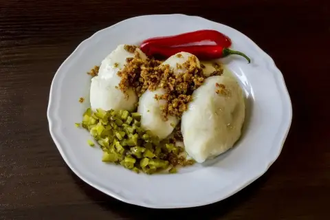 Pyszne kartacze z mięsem, polane skwarkami, z posiekanymi ogórkami i papryczką chili.