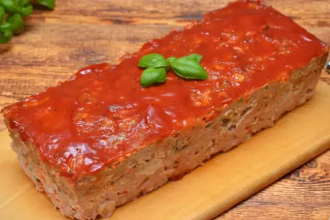 Pyszna pieczeń z mięsa mielonego na kanapki, polana sosem pomidorowym i ozdobiona listkami bazylii. Idealna na rodzinny obiad lub jako dodatek do kanapek.