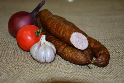 Wędzona kiełbasa, cebula, pomidor i czosnek. Idealne składniki, by zastanowić się, ile soli do kiełbasy dodać.