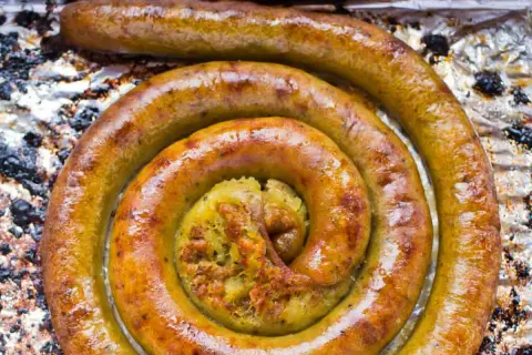 Złocista kiszka ziemniaczana w foremce, upieczona na chrupko, z widocznym farszem w środku.