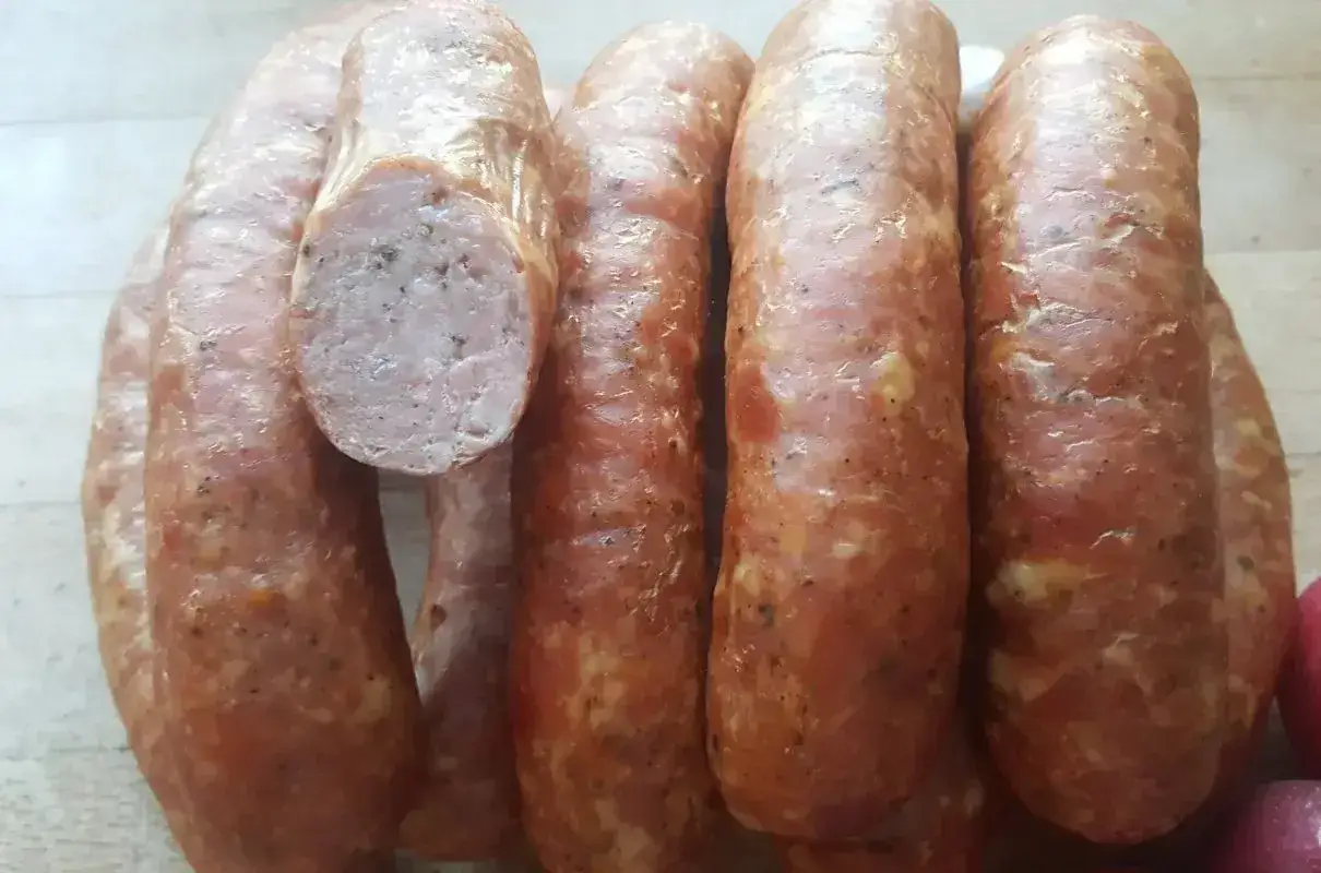 Kilka grubych, wędzonych kiełbas, jedna przekrojona. Idealne do grillowania, zastanawiasz się, ile parzyć kiełbasę wędzoną?
